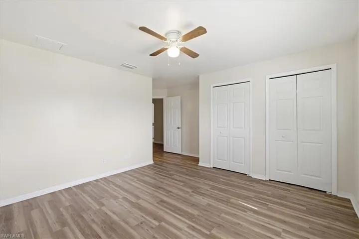 Light-toned wood-finish flooring complements the neutral wall color