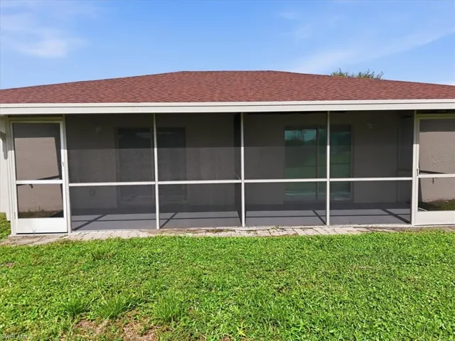 Screened-in patio with concrete flooring and a red shingle roof