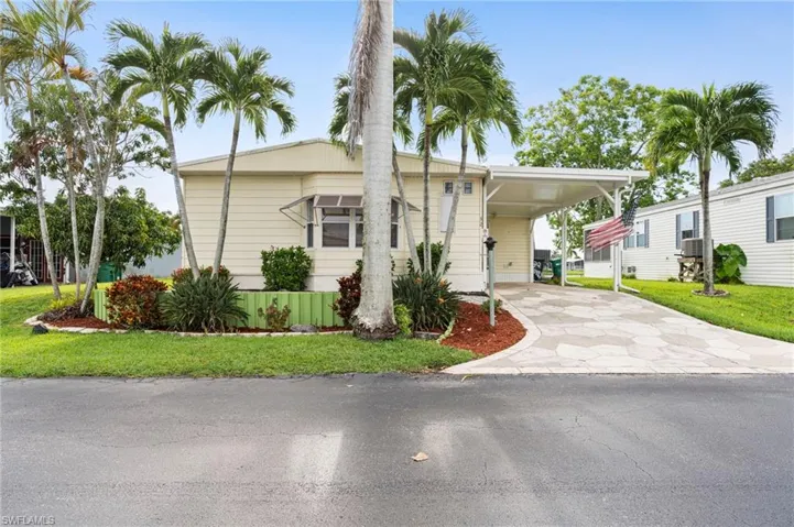 Manufactured / mobile home with a front lawn and a carport