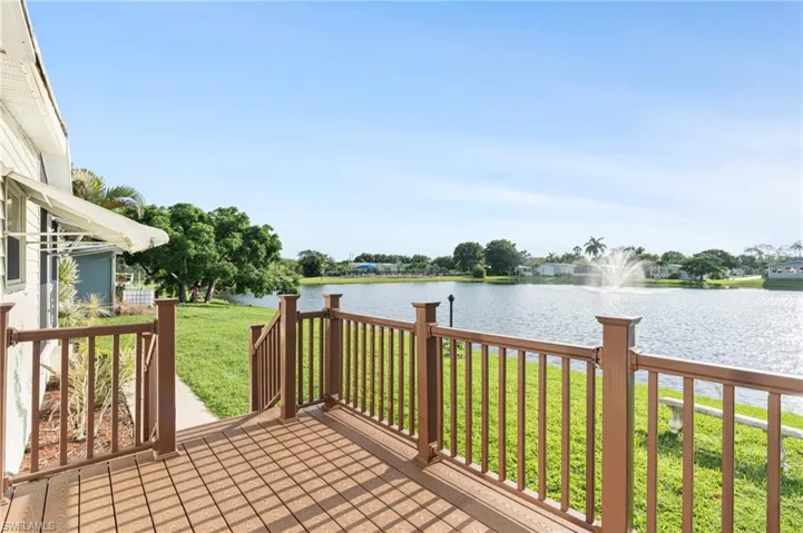 Deck with a yard and a water view