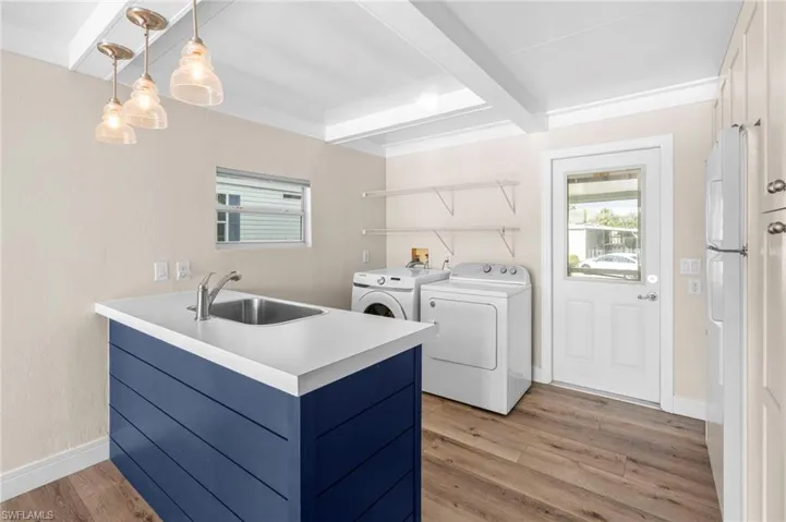 Laundry room featuring light hardwood / wood-style floors, sink, and washer and clothes dryer