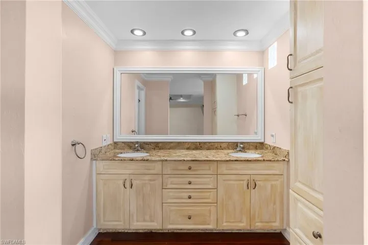 Bathroom featuring hardwood / wood-style floors, ornamental molding, and vanity