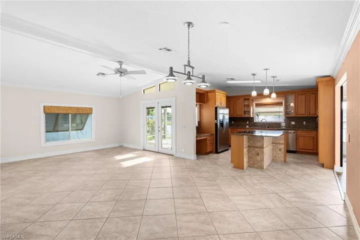 Kitchen featuring a center island, tasteful backsplash, ceiling fan, stainless steel appliances, and lofted ceiling