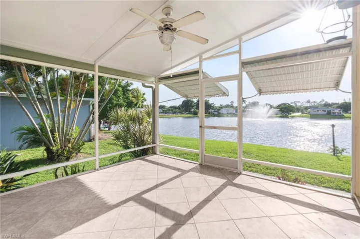 Unfurnished sunroom featuring ceiling fan and a water view