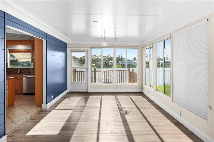 Unfurnished sunroom featuring sink and a water view