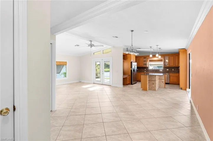 Kitchen featuring backsplash, appliances with stainless steel finishes, a kitchen island, ceiling fan, and a breakfast bar area