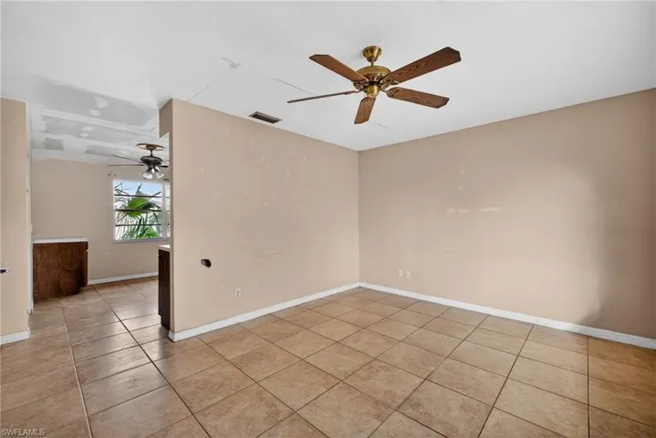 Empty room featuring ceiling fan and light tile patterned floors