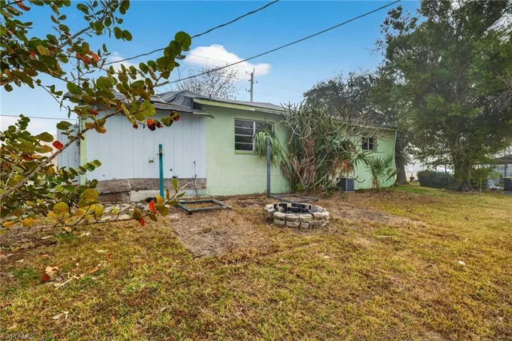 Back of house with a yard and a fire pit