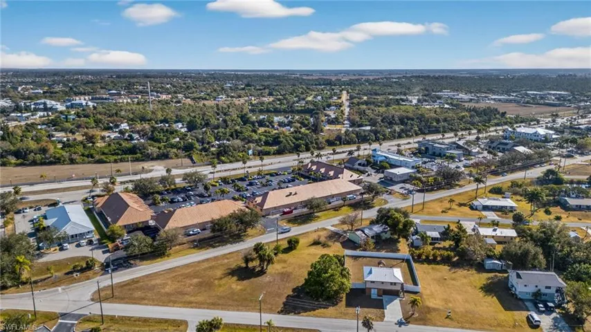 Aerial view of property and surrounding area featuring nearby suburban area