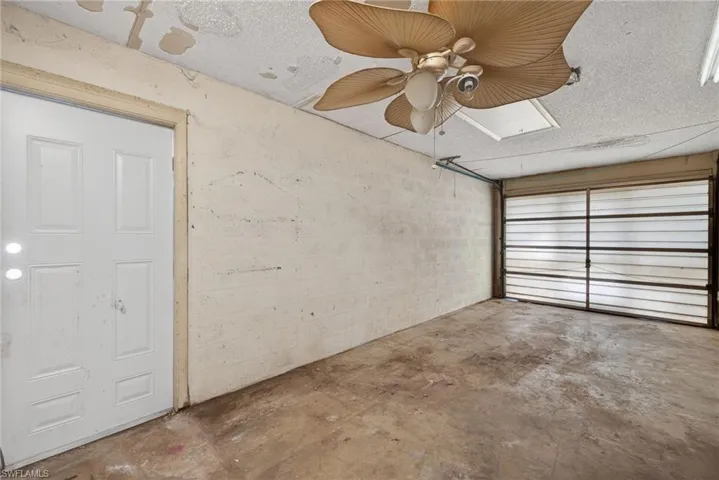 Garage with a ceiling fan and concrete block wall