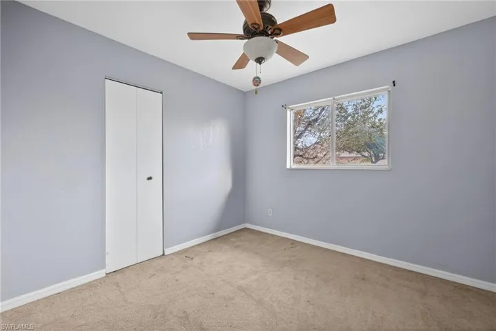 Unfurnished bedroom with carpet floors, a closet, and ceiling fan