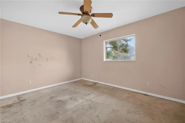 Spare room featuring carpet floors and ceiling fan