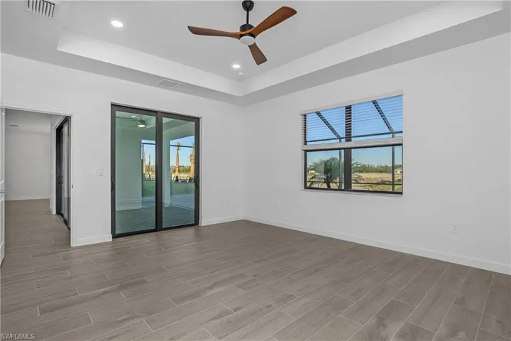 This spacious primary bedroom features beautiful water views and includes private slider entry to screened lanai space and private pool/spa.