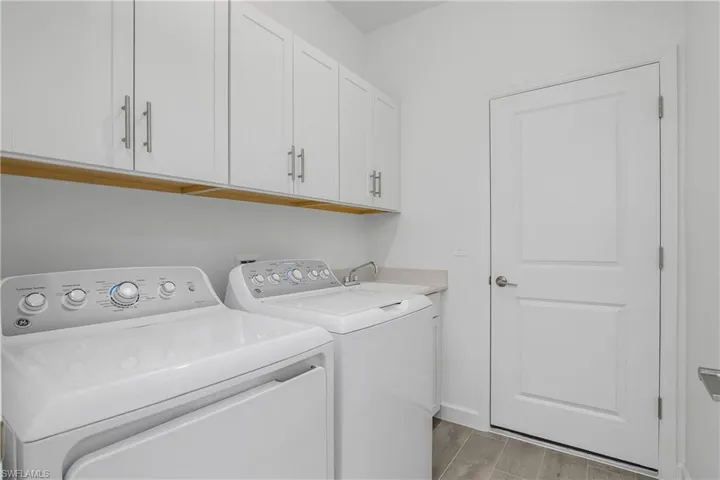 Laundry room includes after-market cabinetry for additional storage and a clean look.
