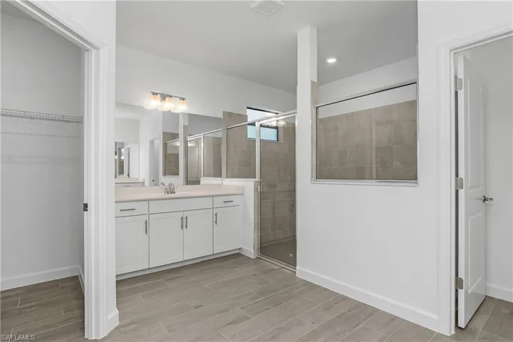 Primary bath features TWO walk-in closets, dual sinks and frameless walk-in shower.