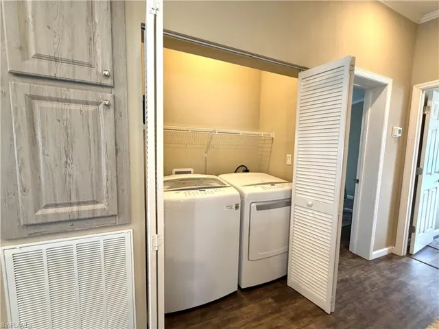 Laundry closet with bi-fold louvered doors, wire shelving, and wood-finish flooring