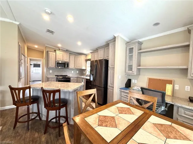 Kitchen with light-toned cabinetry, granite-finish countertops, and built-in stainless steel appliances