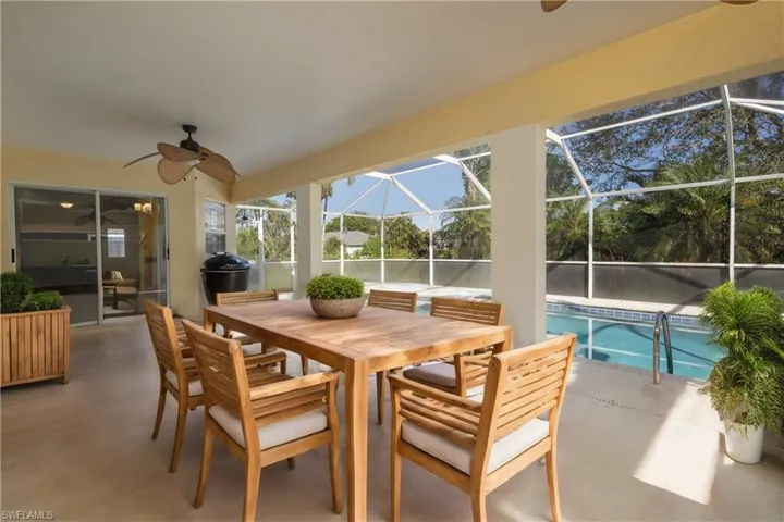 View of patio featuring glass enclosure and ceiling fan