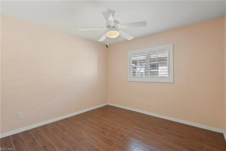 Spare room featuring dark hardwood / wood-style flooring and ceiling fan