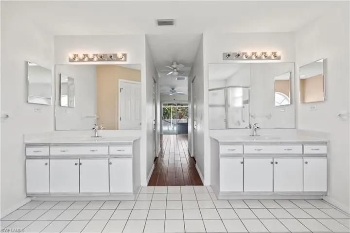 Bathroom with vanity, ceiling fan, hardwood / wood-style floors, and a shower with shower door