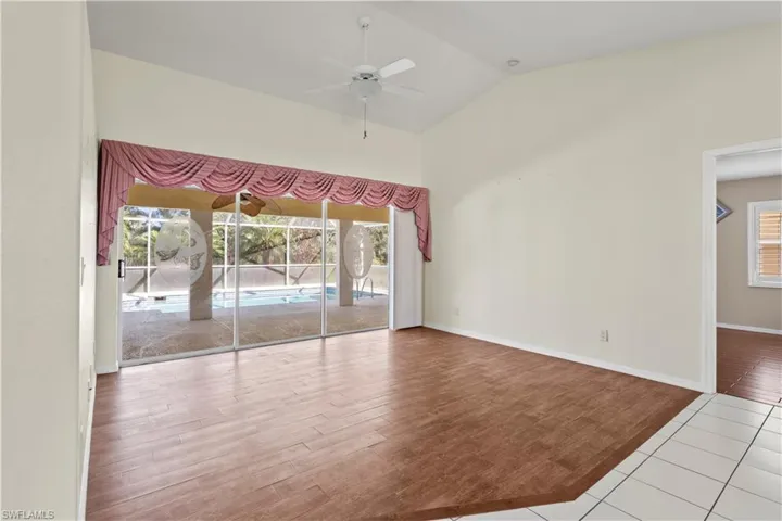 Tiled empty room featuring high vaulted ceiling and ceiling fan