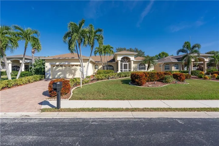 View of front of house with a garage and a front lawn
