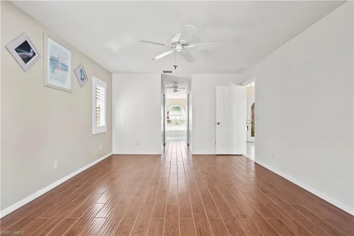 Unfurnished room with hardwood / wood-style floors and ceiling fan
