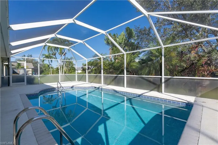 View of pool featuring a patio and glass enclosure