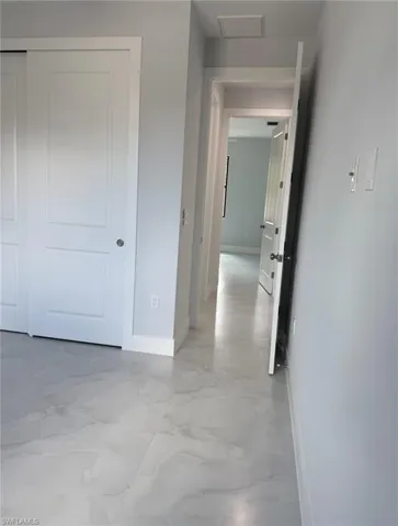 Hallway with baseboards, marble finish floor, and visible vents