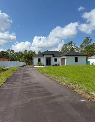 Prairie-style house with a garage, driveway, and stucco siding