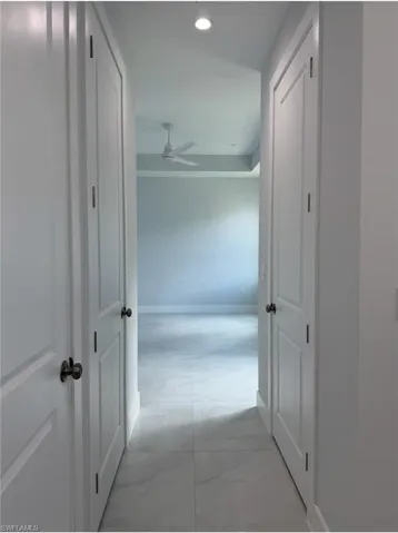 Hall featuring marble finish floor, baseboards, and recessed lighting