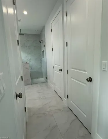 Hall with marble finish floor, visible vents, and recessed lighting