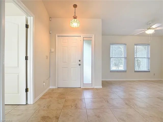 Entryway with light tile patterned floors and ceiling fan