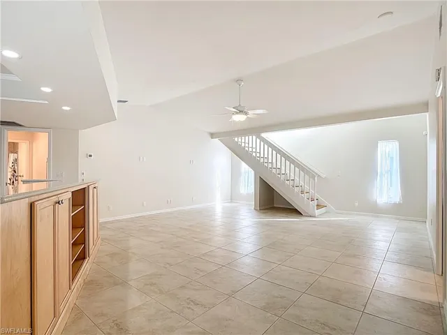 Unfurnished living room with stairway, light tile patterned flooring, recessed lighting, and ceiling fan