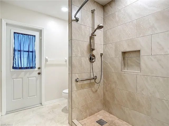 Downstairs Pool Bath and Full bathroom with a stall shower and tile patterned floors