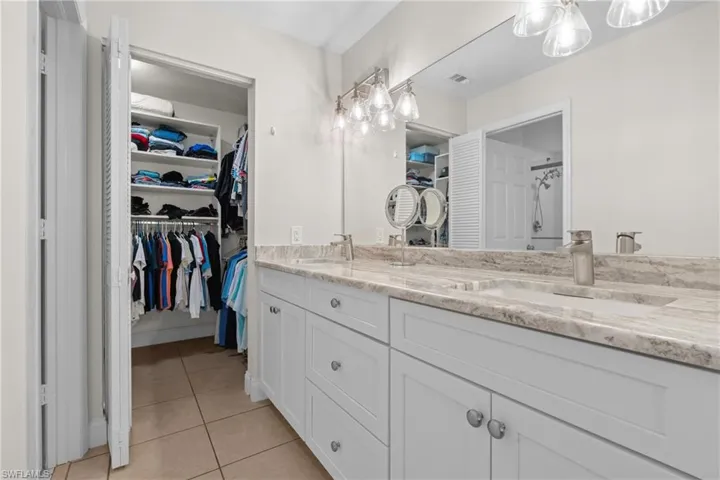 Dual vanity with an integrated sink, light-toned countertop, and modern fixtures