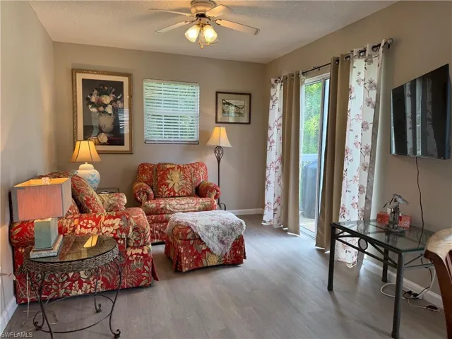 Sitting room with wood finished floors, a textured ceiling, and a ceiling fan