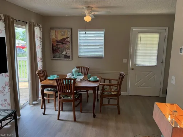Dining area featuring a textured ceiling, wood finished floors, and a ceiling fan