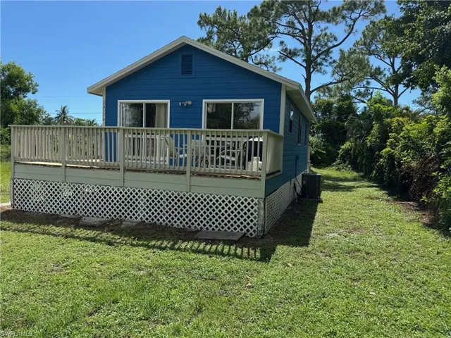 Rear view of property with a wooden deck and a lawn