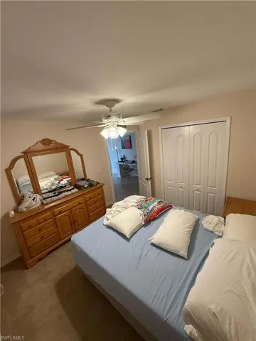 Bedroom featuring light carpet, a closet, and ceiling fan