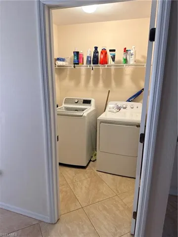 Washroom featuring light tile patterned floors and separate washer and dryer