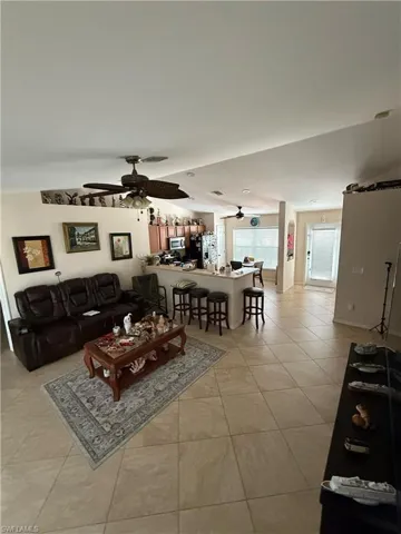 Living room with light tile patterned floors and ceiling fan
