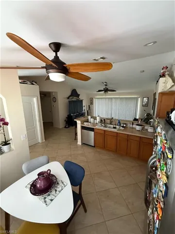 Kitchen featuring light countertops, light tile patterned floors, dishwasher, and brown cabinets