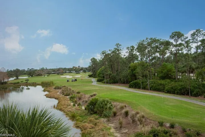 View of community with golf course view, a yard, and a water view