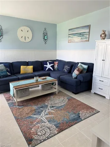 Living area with tile patterned floors and a wainscoted wall