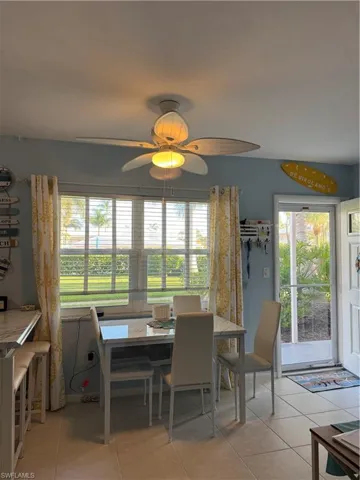 Dining space featuring light tile patterned floors and a ceiling fan
