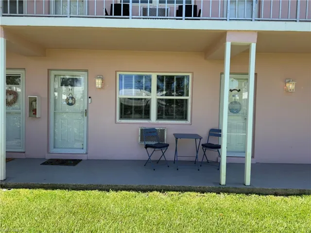 View of exterior entry featuring stucco siding, a patio, and a balcony