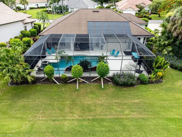 Rear view of house featuring glass enclosure and a yard