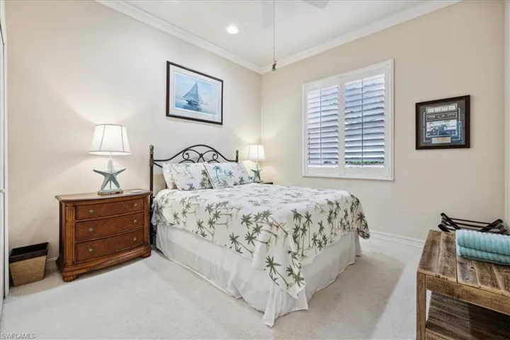 Bedroom featuring crown molding, light colored carpet, and ceiling fan