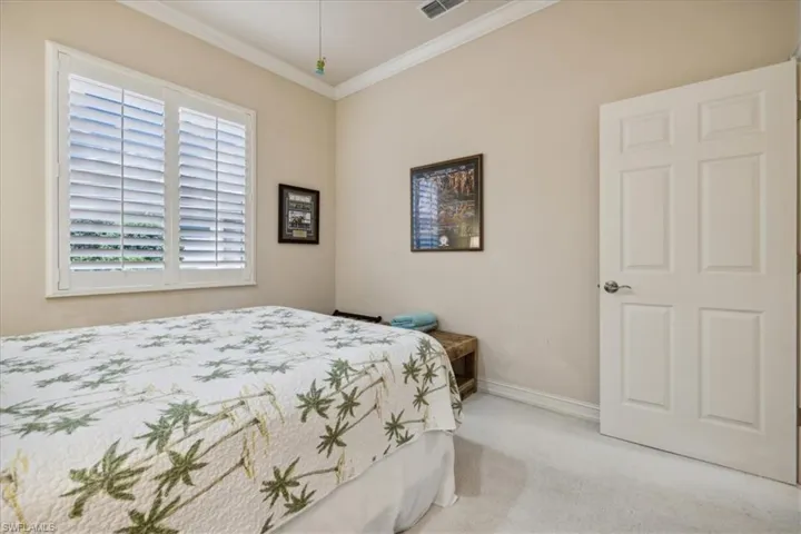 Bedroom featuring carpet floors and crown molding